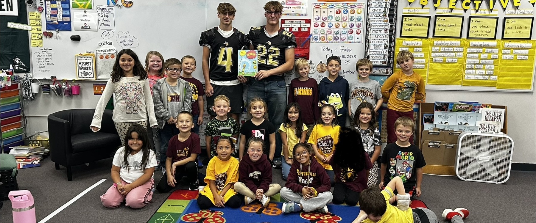 Varsity students reading to Elementary students